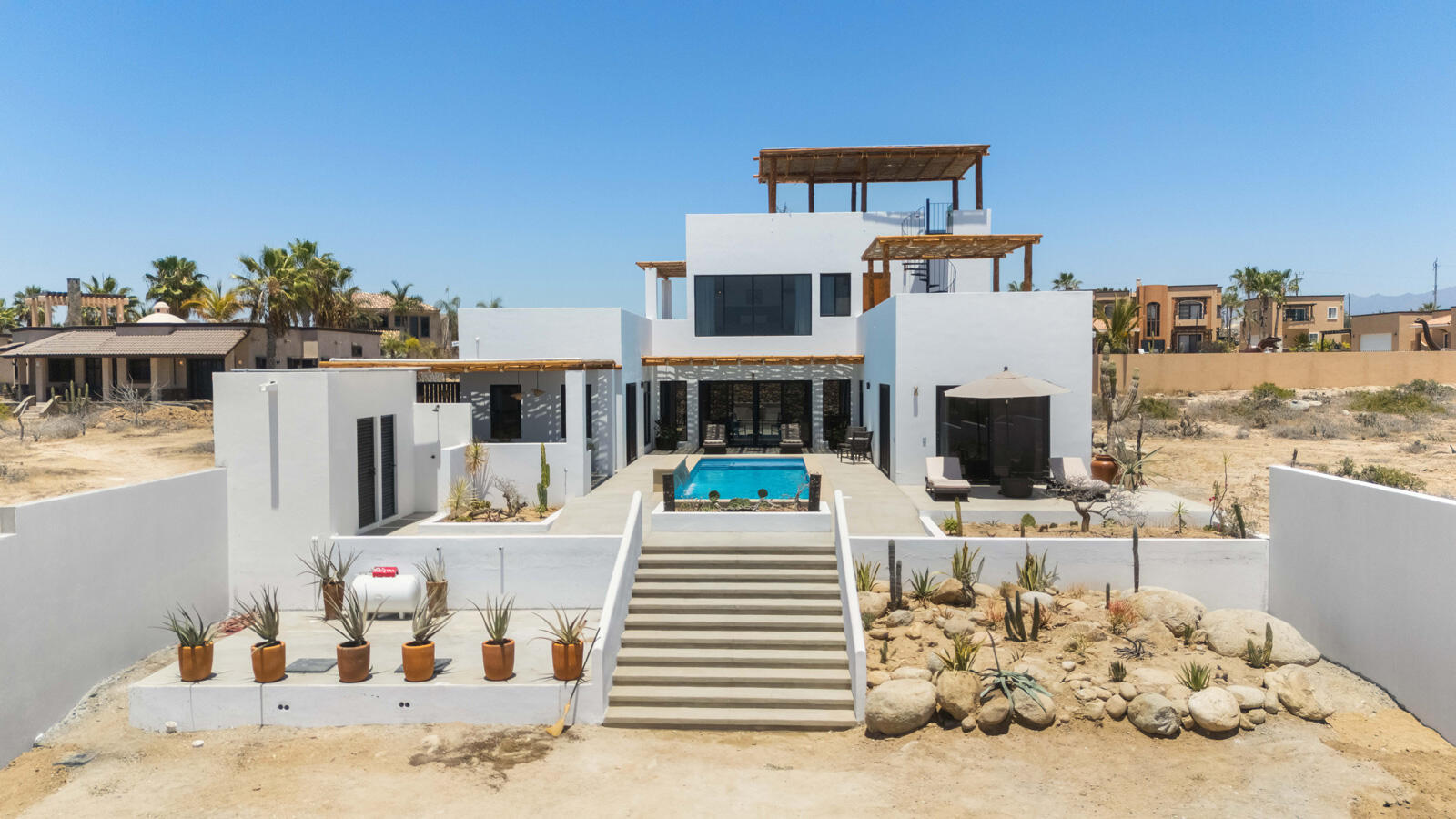Chileno Bay El Posito We are excited to introduce Casa Elisabeth, an amazing, newly constructed custom home in the private El Posito area of Todos Santos. Located just three rows back from the beach, this three-bedroom, three-full and two-half bathroom residence offers every amenity desired for a tropical paradise. The downstairs features an open-concept living room, dining room, and a fully stocked kitchen with brand-new appliances, including a dishwasher. The main floor also includes a laundry room and an outdoor water feature with a professionally designed rock wall. The principal bedroom downstairs offers a unique indoor/outdoor bathroom with two showers and an outdoor bathtub.Each of the three bedrooms includes an en-suite bathroom with double vanities. The upstairs bedroom features its own private furnished terrace and access to one of four large patios, complete with a bar area and outdoor furniture perfect for enjoying ocean sunsets. Additionally, a shaded third-floor observation deck provides panoramic ocean and mountain – Casa Elisabeth, Pacific, Pacific, BS